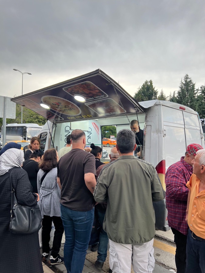 Tatlıcı Mustafa mobil lokma aracında lokma dağıtımı bekleyen kalabalık